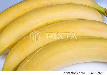 Vibrant tropical imagery. Bright bananas with shadows craft island scene. Vividly hued bananas with subtle shadows illustrate lively and warm island paradise setting Vibrant tropical imagery. Bright bananas with shadows craft island scene. Vividly hued bananas with subtle shadows illustrate lively and warm island paradise setting 137822699