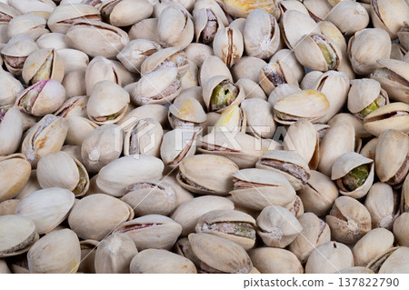 Selective focus pistachios cluster, shallow depth of field highlights split shells and bright green kernel peeks, moody soft lighting for editorial food photography Selective focus pistachios cluster, shallow depth of field highlights split shells and bright green kernel peeks, moody soft lighting for editorial food photography 137822790