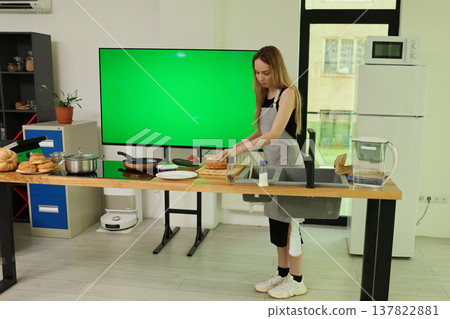 Cooking in a bright kitchen with a green screen backdrop during a lively food preparation session Cooking in a bright kitchen with a green screen backdrop during a lively food preparation session 137822881