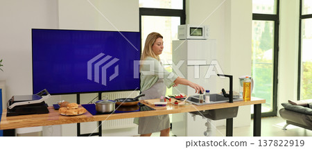 Captivating moments in a sunny kitchen as a woman prepares breakfast with fresh ingredients and modern appliances Captivating moments in a sunny kitchen as a woman prepares breakfast with fresh ingredients and modern appliances 137822919