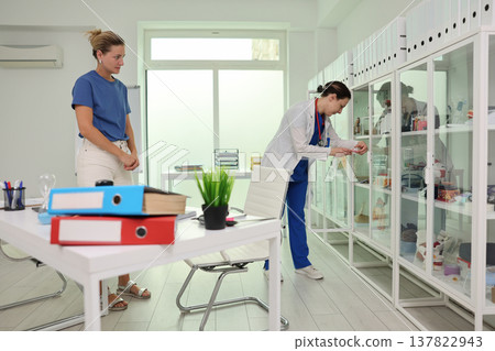 Busy healthcare professionals organize supplies in a modern clinic setting during a weekday afternoon Busy healthcare professionals organize supplies in a modern clinic setting during a weekday afternoon 137822943