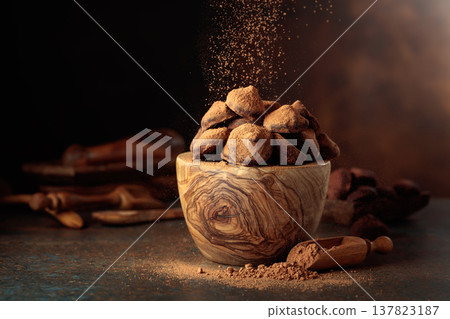 Chocolate truffles in wooden dish are sprinkled with cocoa powder. Chocolate truffles in wooden dish are sprinkled with cocoa powder. 137823187
