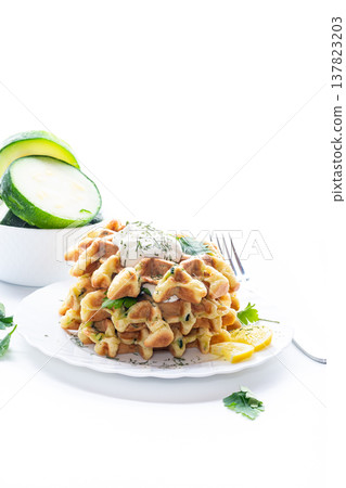 homemade zucchini waffles with creamy topping and fresh herbs 137823203