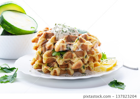 homemade zucchini waffles with creamy topping and fresh herbs 137823204