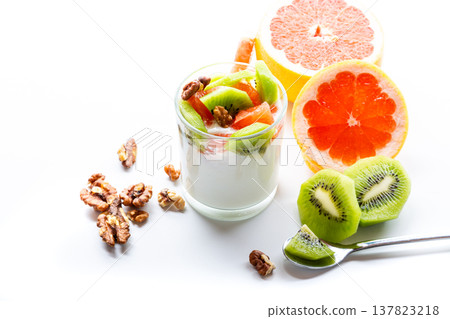 Fresh yogurt dessert with fruit and nuts on a white background Fresh yogurt dessert with fruit and nuts on a white background 137823218