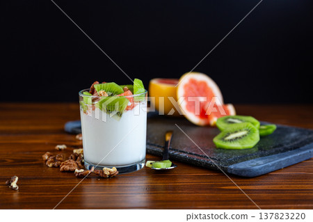 layered yogurt with fresh fruit pieces and walnut topping layered yogurt with fresh fruit pieces and walnut topping 137823220