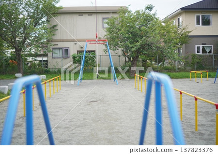 An empty park with swings and playground equipment; an image of the quiet everyday life in a residential area and a children's playground. An empty park with swings and playground equipment; an image of the quiet everyday life in a residential area and a children's playground. 137823376