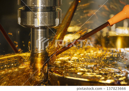 Close-up of a CNC milling machine using the oil coolant method to cut high-precision mold parts. 137823666