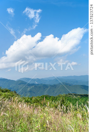 From the summit of Mt. Bōnoori (Bōnomine), a view of the autumn blue sky, rising white clouds, and the mountain ranges of Chichibu and Okutama. 137823724