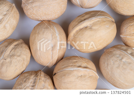 Tight walnuts in shells baking pattern, repetitive layout suggests pastry or dessert prep, proteinrich motif with crunchy visual cues and soft shadows to enhance appetite appeal Tight walnuts in shells baking pattern, repetitive layout suggests pastry or dessert prep, proteinrich motif with crunchy visual cues and soft shadows to enhance appetite appeal 137824501