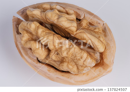 Half of walnut showcasing complex folds and textures. Minimalist depiction of walnut half emphasizing detailed textures against neutral background for artistic inspiration Half of walnut showcasing complex folds and textures. Minimalist depiction of walnut half emphasizing detailed textures against neutral background for artistic inspiration 137824507