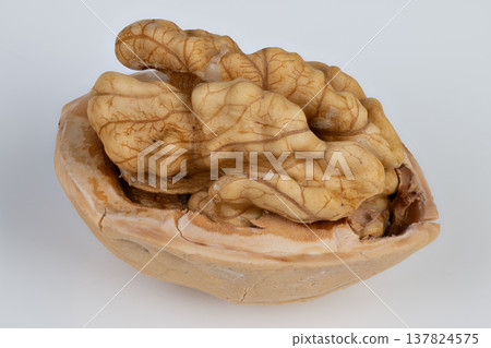 Isolated walnut half showcasing omega fatty acids for health benefits. Clean white backdrop features walnut half emphasizing essential omega and healthy fats for nutrition 137824575