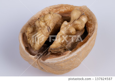 Premium baking nut. Highquality walnut half suitable for baking and pastry decoration. Elegant single walnut slice showcasing natural oils and crunchy texture for culinary use 137824587