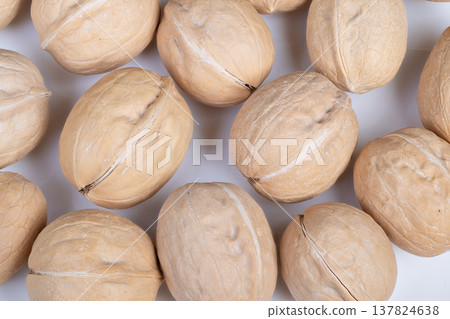 Seasonal walnuts in shells arranged for festive cuisine display. Prepped walnuts in their shells illustrated for cozy holiday baking and seasonal culinary themes 137824638