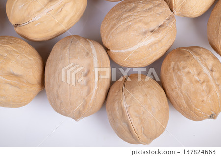 Simple arrangement of shelled nuts. Clean layout emphasizing design contrast in walnut presentation. Pure visual display focusing on form and hue of plain shelled walnuts 137824663