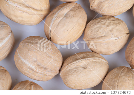 Rustic walnut display attracts buyers. Freshly shelled walnuts evoke traditional market vibe. Artisan walnuts arranged on surface highlight natural and rustic charm Rustic walnut display attracts buyers. Freshly shelled walnuts evoke traditional market vibe. Artisan walnuts arranged on surface highlight natural and rustic charm 137824673
