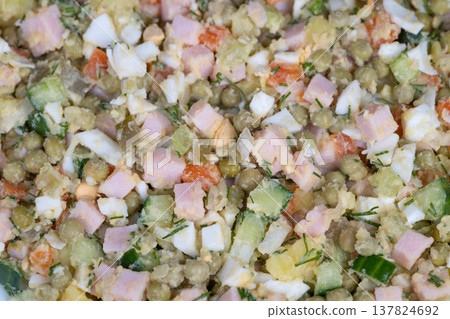 Salad detailed view. Closeup of fresh Olivier salad. Diced Olivier salad with herbs and peas. An upclose depiction of freshly prepared Olivier salad with herbs and colorful peas Salad detailed view. Closeup of fresh Olivier salad. Diced Olivier salad with herbs and peas. An upclose depiction of freshly prepared Olivier salad with herbs and colorful peas 137824692