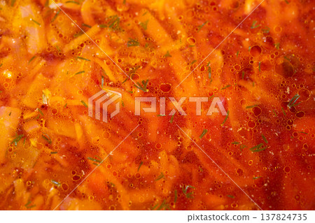 Styled borscht soup vibrant red, composed for editorial with herb sprinkles and visible potato cubes, glossy broth texture and mouthwatering appeal for food photography 137824735