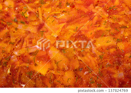 Homemade Beet Soup. Rustic home cooked vegetable soup. Steaming traditional borscht with fresh herbs. Closeup of hearty homemade soup with shredded vegetables and herbs 137824769
