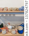 Handmade ceramic mugs and torso cups on display 137824797