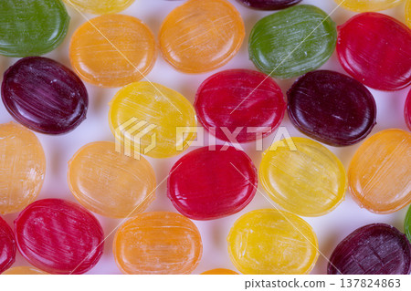 Colorful variety of glossy confections displayed on simple background image. An energetic portrayal of vibrant assortment of shiny candies captured in closeup for vivid detail Colorful variety of glossy confections displayed on simple background image. An energetic portrayal of vibrant assortment of shiny candies captured in closeup for vivid detail 137824863