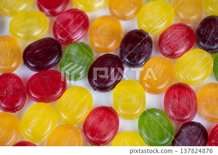 Multicolored hard candies arranged on stark white background for decoration. Variety of lively colored candies scattered across white backdrop suitable for festive displays Multicolored hard candies arranged on stark white background for decoration. Variety of lively colored candies scattered across white backdrop suitable for festive displays 137824876