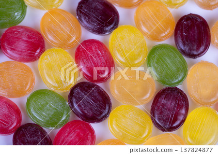 Multicolored candies form rhythmic pattern under macro lens, repeating circular shapes create graphic texture and symmetry, suitable for abstract backgrounds and modern design Multicolored candies form rhythmic pattern under macro lens, repeating circular shapes create graphic texture and symmetry, suitable for abstract backgrounds and modern design 137824877