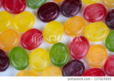 Seasonal multicolored hard candies arranged to evoke holiday stocking fillers, warm glow and nostalgic tone, suitable for greeting card or seasonal promotion visuals Seasonal multicolored hard candies arranged to evoke holiday stocking fillers, warm glow and nostalgic tone, suitable for greeting card or seasonal promotion visuals 137824893