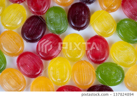 Macro multicolored hard candy detail with visible sugar grains and surface ridges, artisan confection study for food designer or chocolatier inspiration and texture reference 137824894