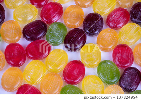 Abstract multicolored candies arranged in pattern, repetitive geometry, glossy highlights, decorative motif, textile or wallpaper potential, highcontrast colors 137824954