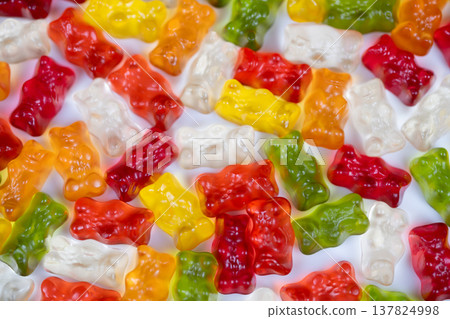 Brightly hued gummy bears form artistic mosaic surface. An array of multicolored gummy bears creates artistic mosaic with soft shadows and textured feel for promotional displays Brightly hued gummy bears form artistic mosaic surface. An array of multicolored gummy bears creates artistic mosaic with soft shadows and textured feel for promotional displays 137824998