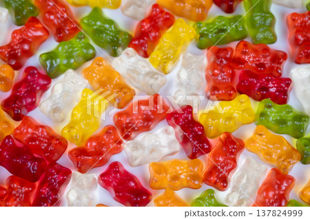 Shiny multicolored gummy bears glistening under bright light, high gloss reflections and saturated tones create mouthwatering sensory appeal for food, ASMR, and advertising use Shiny multicolored gummy bears glistening under bright light, high gloss reflections and saturated tones create mouthwatering sensory appeal for food, ASMR, and advertising use 137824999