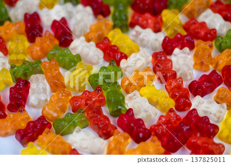 Macro glossy gummy bears resembling candy jewels, highcontrast highlights and translucent edges emphasize gemlike quality and tactile shine for luxury confection visuals 137825011