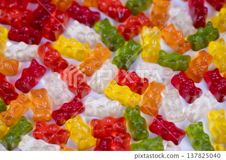 Assessment of translucent gummy candies for appearance. Industrial setting showcasing diverse gummy confections being evaluated for color and surface finish integrity Assessment of translucent gummy candies for appearance. Industrial setting showcasing diverse gummy confections being evaluated for color and surface finish integrity 137825040