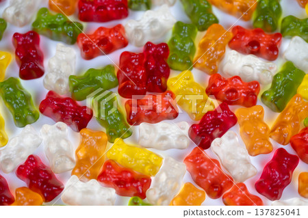Colorful gummy bears arrange into appealing snack display full of fun. Lively gummy bears of various colors are assembled to create playful and attractive snack arrangement Colorful gummy bears arrange into appealing snack display full of fun. Lively gummy bears of various colors are assembled to create playful and attractive snack arrangement 137825041