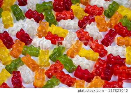 Festive gummy bears. Vivid gummy bears spread like confetti signaling holiday cheer. Lively assortment of candies in festive colors enhances promotional seasonal displays Festive gummy bears. Vivid gummy bears spread like confetti signaling holiday cheer. Lively assortment of candies in festive colors enhances promotional seasonal displays 137825042