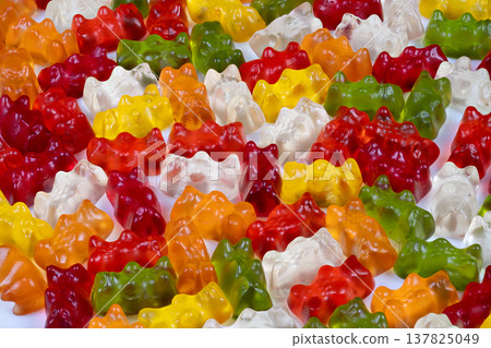 Topdown mosaic of multicolored gummy bears arranged in playful layout, repeating motifs and saturated hues create eyecatching pattern for editorial backgrounds and surface designs Topdown mosaic of multicolored gummy bears arranged in playful layout, repeating motifs and saturated hues create eyecatching pattern for editorial backgrounds and surface designs 137825049