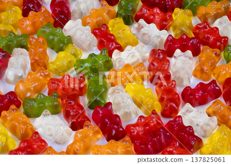 Vibrant gummy bears illuminated by focused lighting. An artistic portrayal of multicolored gummy bears under controlled studio illumination and refined composition 137825061