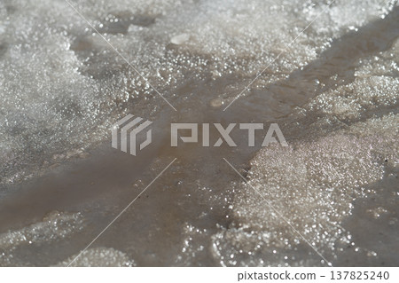 Seasonal snow transformation. Spring melt shapes nature. Melting terrain molds fresh spring waterways. Flowing melt transforms frozen landscape into vibrant seasonal scenery 137825240