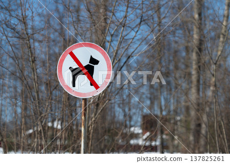 Warning sign for animal protection. Protection message displayed near trees and houses. Sign warning visitors to protect local animals in tranquil natural surroundings 137825261