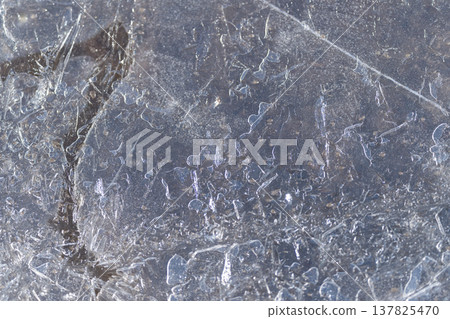 Polished thawed ice displays subtle shimmer and scratches. Smoothly thawed ice plane exhibits faint scratches along with soft reflective glow across its surface 137825470
