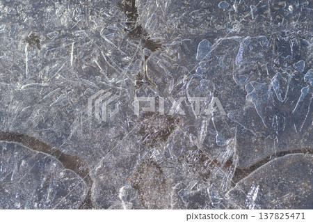 Intricate frost and speckle designs. Delicate ice patterns with subtle markings. Elaborate frost patterning on ice with fine speckles and understated scratch marks 137825471