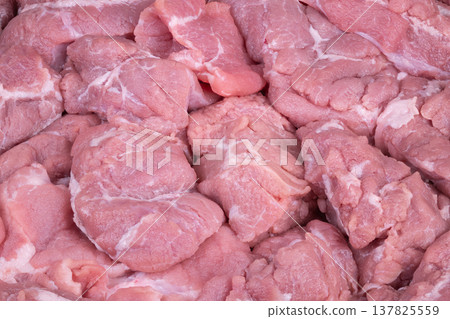 Bulk arrangement of fresh pork meat for efficient processing and manufacturing. Factory setting where large quantities of fresh pork are systematically prepared for processing 137825559
