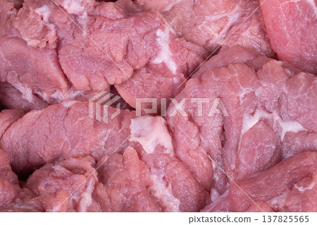 Butcher display fresh meat arranged on tray, multiple pork cuts with visible marbling and fat seams, refrigerated setting suggests cleanliness and retail readiness for consumers Butcher display fresh meat arranged on tray, multiple pork cuts with visible marbling and fat seams, refrigerated setting suggests cleanliness and retail readiness for consumers 137825565