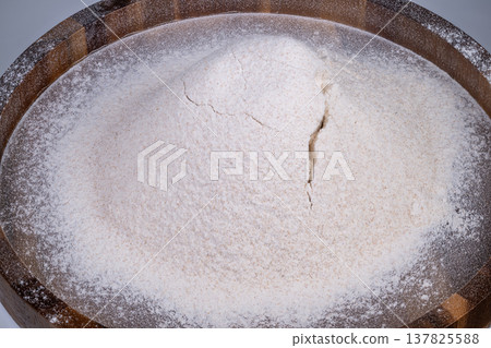 White flour evenly spread on surface. Clean background featuring neutral flour spread. Flat surface covered with uniform layer of white flour and soft dusting edge White flour evenly spread on surface. Clean background featuring neutral flour spread. Flat surface covered with uniform layer of white flour and soft dusting edge 137825588