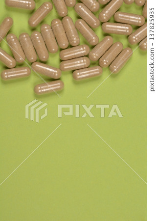 Brown capsules on green background with copy space Brown capsules on green background with copy space 137825935