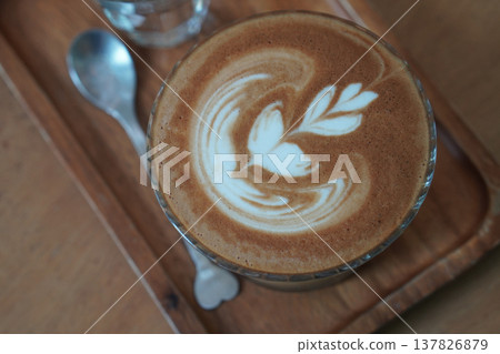 top view brown coffee in low glass on wooden tray, silver spoon and water in glass, brown wooden floor background, drink, cool, food, copy space 137826879