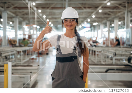 Professional occupation, standing. Woman is in the window making factory Professional occupation, standing. Woman is in the window making factory 137827023