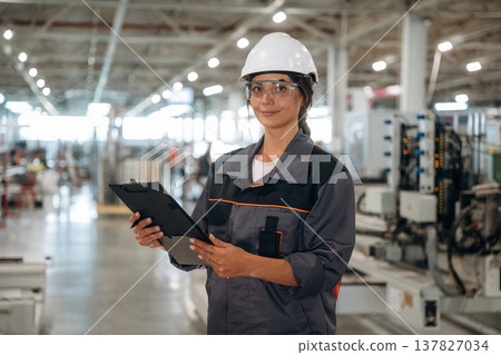 Modern window making factory, woman in professional uniform is standing Modern window making factory, woman in professional uniform is standing 137827034