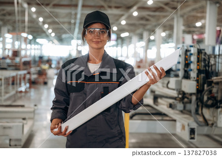 Professional uniform. Woman is in the window making factory Professional uniform. Woman is in the window making factory 137827038